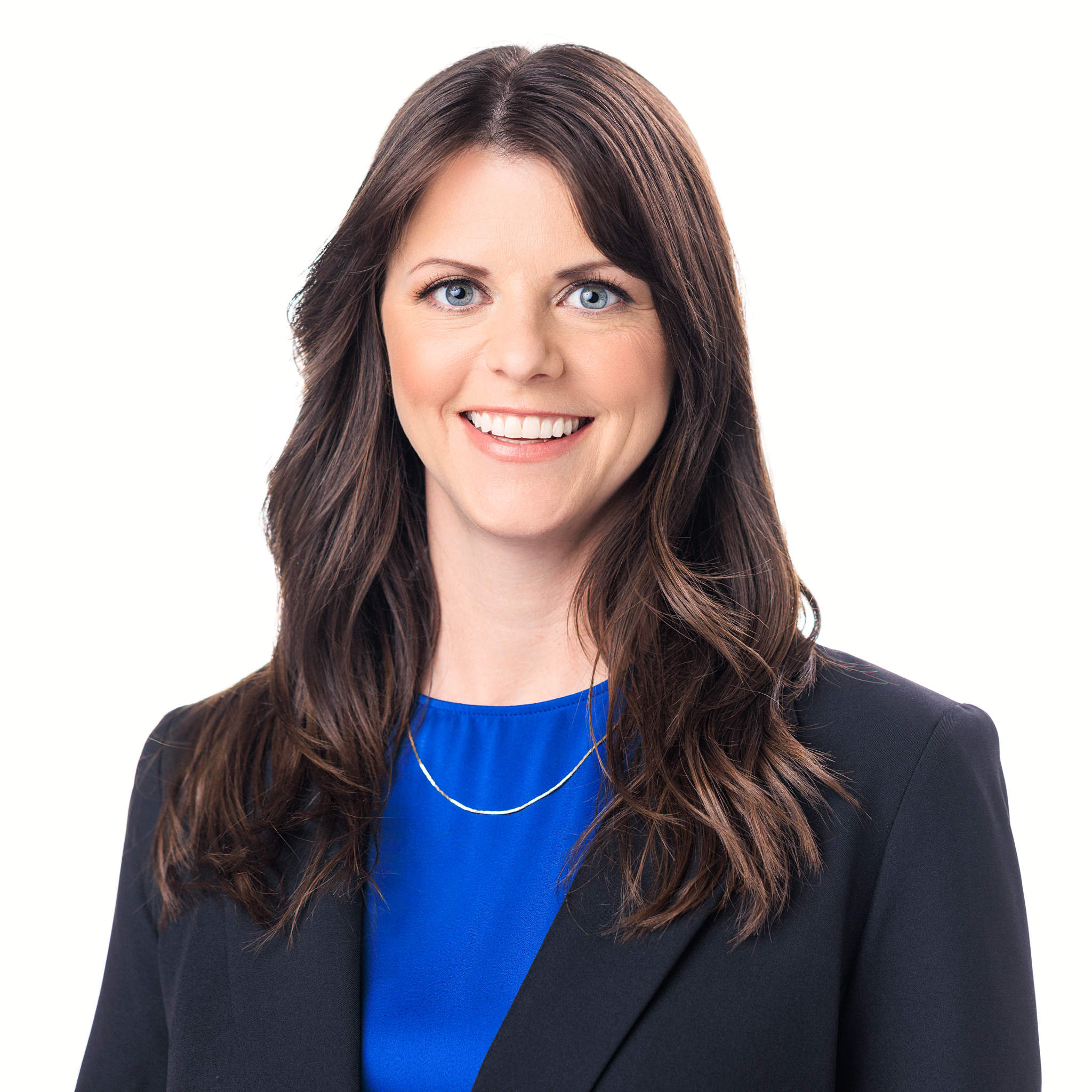 woman with brown hair wearing a blue shirt and a black suit jacket